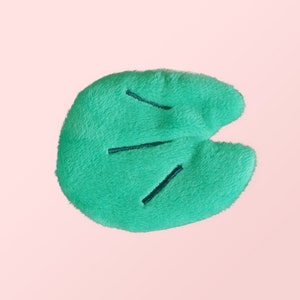 Puede incluir: Una hoja de felpa verde con venas bordadas, perfecta para un animal de peluche o un proyecto de manualidades.