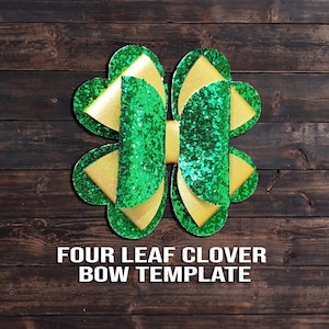 May include: A green and gold four-leaf clover bow template. The bow is made of glitter fabric and has a gold center.