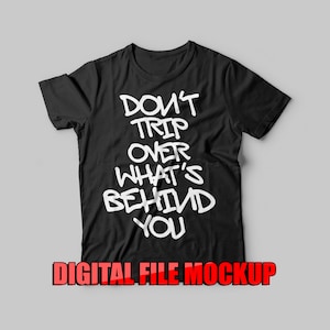 May include: Black t-shirt with white text that reads "Don't trip over what's behind you".
