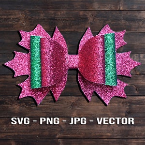 Puede incluir: Un lazo de purpurina rosa con rayas de purpurina verde. El lazo está sobre un fondo de madera marrón.