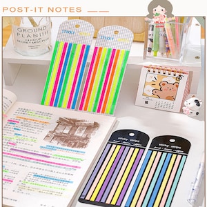 May include: Two packs of colorful sticky note strips. The first pack has 10 neon colored strips, the second pack has 10 pastel colored strips. The strips are labeled "sticky notes" and "sticky strips".