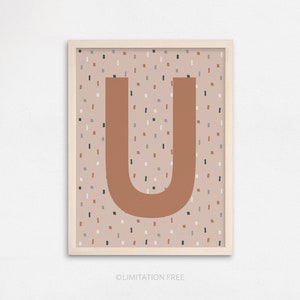 Puede incluir: L&aacute;mina enmarcada con la letra "U" en color &oacute;xido sobre un fondo moteado beige, gris y marr&oacute;n. La impresi&oacute;n est&aacute; en un marco de madera clara. El texto "LIMITATION FREE" est&aacute; en la parte inferior.