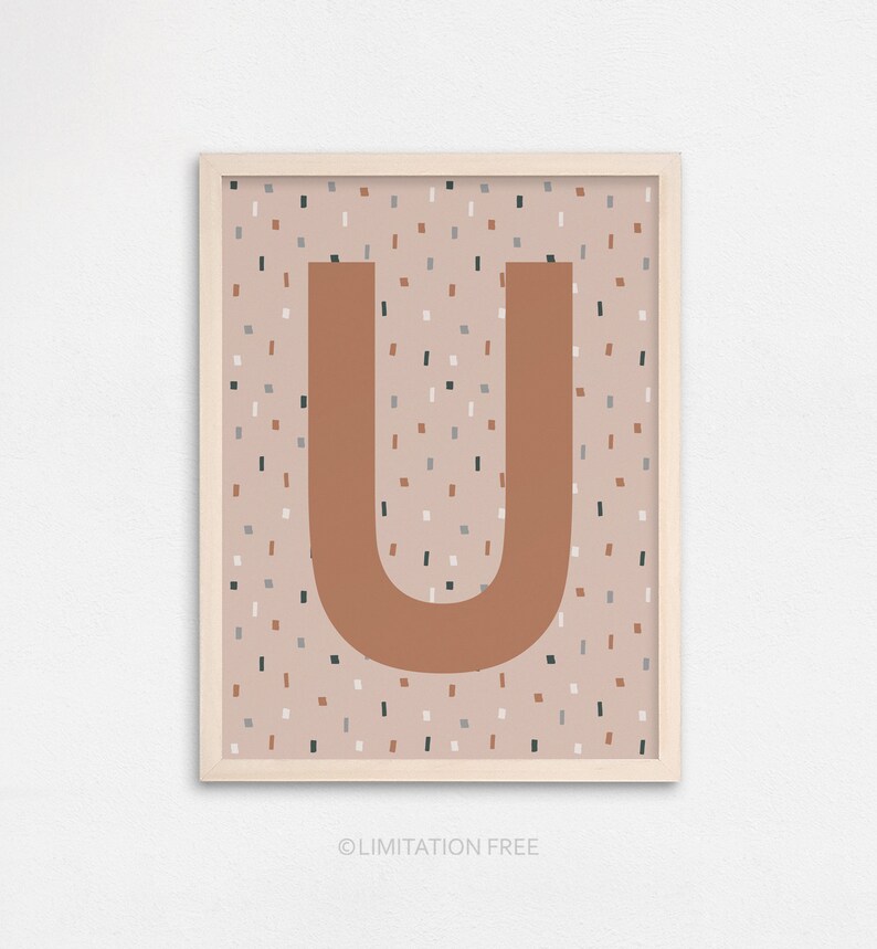 Puede incluir: L&aacute;mina enmarcada con la letra "U" en color &oacute;xido sobre un fondo moteado beige, gris y marr&oacute;n. La impresi&oacute;n est&aacute; en un marco de madera clara. El texto "LIMITATION FREE" est&aacute; en la parte inferior.