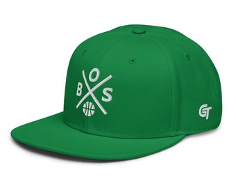 Può includere: Un cappellino snapback verde brillante con un logo ricamato in bianco sul davanti, che presenta le lettere B, O, S disposte attorno a un'icona di pallone da basket. Il lato del cappellino mostra un piccolo logo GT bianco e visiera piatta.