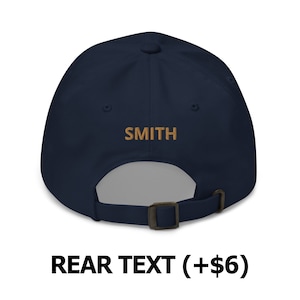 May include: A navy blue baseball cap with an adjustable strap and the word "SMITH" embroidered on the back in a gold color.