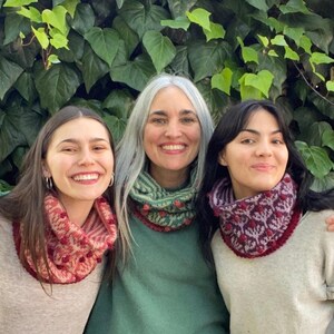 Puede incluir: Tres personas con calentadores de cuello de punto de colores. Los calentadores de cuello tienen un patrón floral y están hechos con una variedad de colores, incluyendo rojo, verde, morado y blanco.