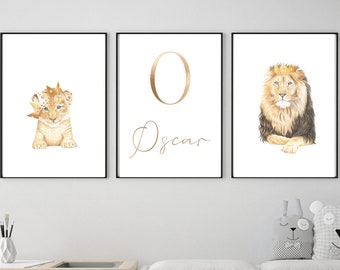 May include: Three framed prints with a lion cub wearing a crown, the letter O in gold, and a lion wearing a crown. The prints are on a white background and have black frames. The middle print has the name Oscar written in gold cursive.