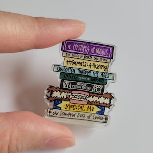May include: A stack of colorful, illustrated books with titles like "A History of Magic", "Hogwarts: A History", "Quidditch Through the Ages", "Defense Against the Dark Arts", "Advanced Potion Making", and "Magical Me: The Standard Book of Spells".