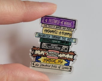 Pin acrílico de pila de libros de mago