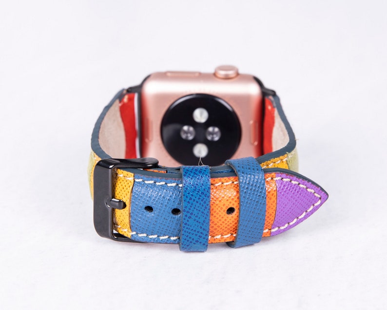 Puede incluir: Una correa de reloj de cuero colorida con una hebilla negra. La correa est&aacute; hecha de m&uacute;ltiples rayas de cuero amarillo, naranja, azul y morado.
