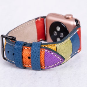 Puede incluir: Una correa de reloj de cuero colorida con un patr&oacute;n geom&eacute;trico azul, naranja, amarillo, verde y morado. La correa est&aacute; dise&ntilde;ada para adaptarse a un Apple Watch.