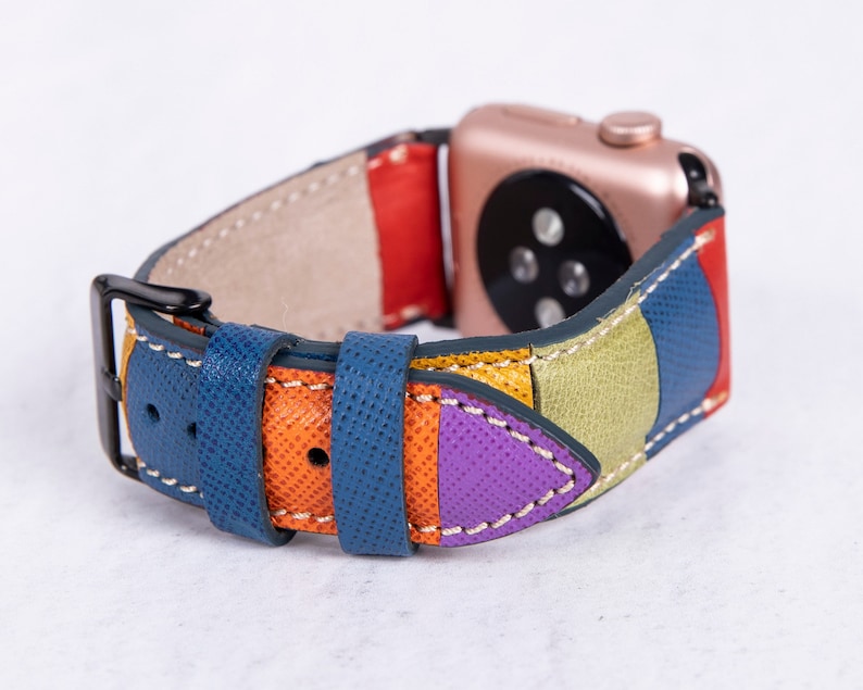 Puede incluir: Una correa de reloj de cuero colorida con un patr&oacute;n geom&eacute;trico azul, naranja, amarillo, verde y morado. La correa est&aacute; dise&ntilde;ada para adaptarse a un Apple Watch.