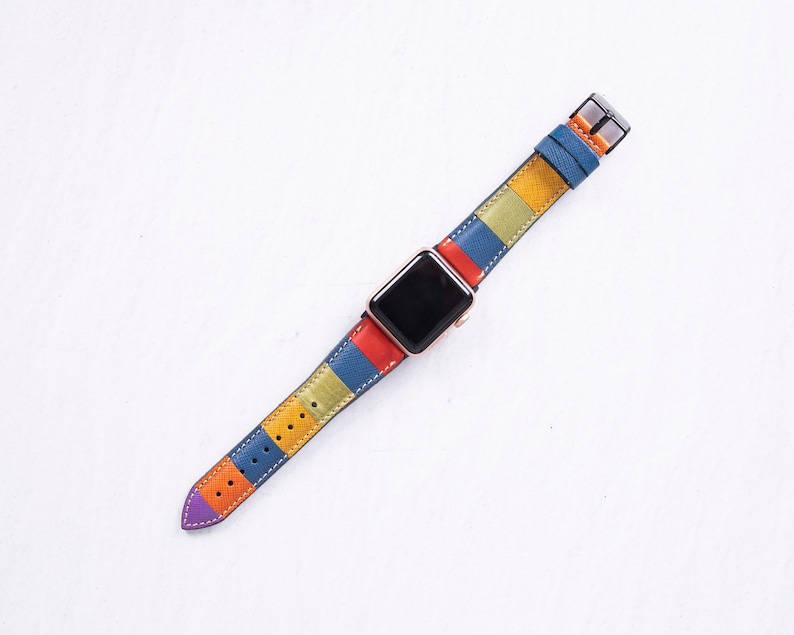 Puede incluir: Una correa de reloj a rayas de colores con una esfera negra. La correa est&aacute; hecha de cuero y tiene una variedad de colores, incluyendo rojo, naranja, amarillo, azul y verde.