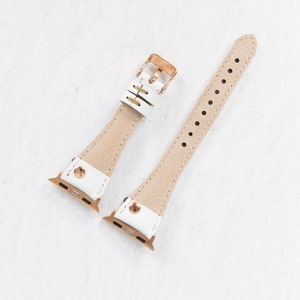 Pode incluir: Duas pulseiras de rel&oacute;gio de couro branco com ferragens de ouro rosa. As pulseiras s&atilde;o projetadas para Apple Watches.