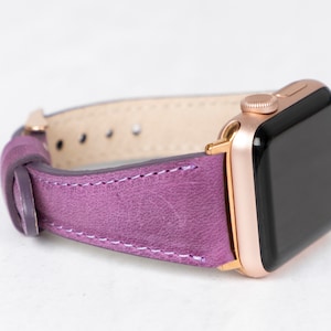 May include: A purple leather watch band with a rose gold Apple Watch.