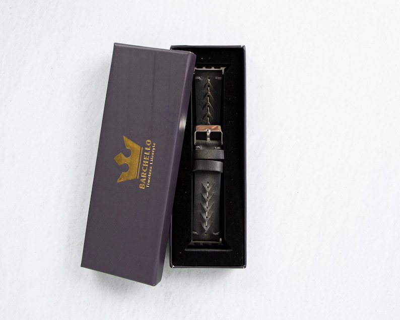 May include: A black leather watch strap with a braided design is displayed in a black box with a gold crown logo that says "Barchello Timeless Elegance".