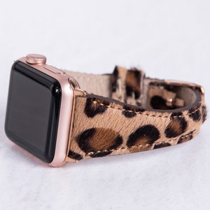 May include: A rose gold Apple Watch with a leopard print leather band.