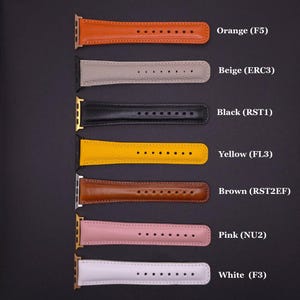K&ouml;nnte beinhalten: Eine Auswahl an Leder-Armb&auml;ndern in verschiedenen Farben, darunter Orange, Beige, Schwarz, Gelb, Braun, Rosa und Wei&szlig;. Jedes Band hat eine Reihe von L&ouml;chern zur Anpassung und ist mit einem Code versehen.
