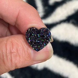 May include: A black heart-shaped glitter sticker with iridescent glitter.