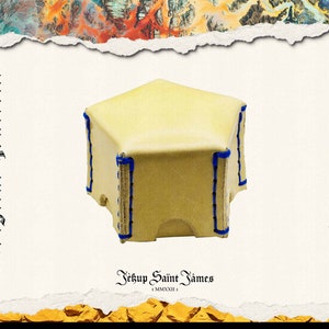 May include: A small, cream-colored leather tent with blue stitching around the edges. The text "Digital Dungeon" and "Leather Craft" are printed vertically on either side. The text "Jekup Saint James" is printed at the bottom.