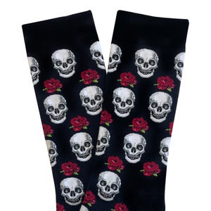 May include: Black socks with a repeating pattern of white skulls and red roses. The socks are made of a soft material and are suitable for everyday wear. The design is a gothic or alternative style.