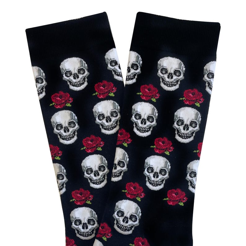 May include: Black socks with a repeating pattern of white skulls and red roses. The socks are made of a soft material and are suitable for everyday wear. The design is a gothic or alternative style.