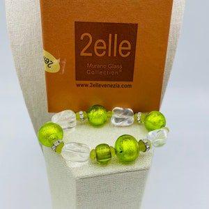 Peut inclure: Un bracelet de perles en verre vert et transparent avec des accents argentés. Le bracelet est fabriqué par 2elle Murano Glass Collection. L'adresse du site Web est www.2ellevenezia.com.