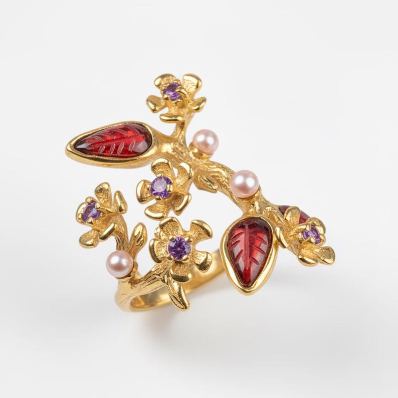 Sakura flower ring blending gold tones and pink gemstone elegance in floral design.