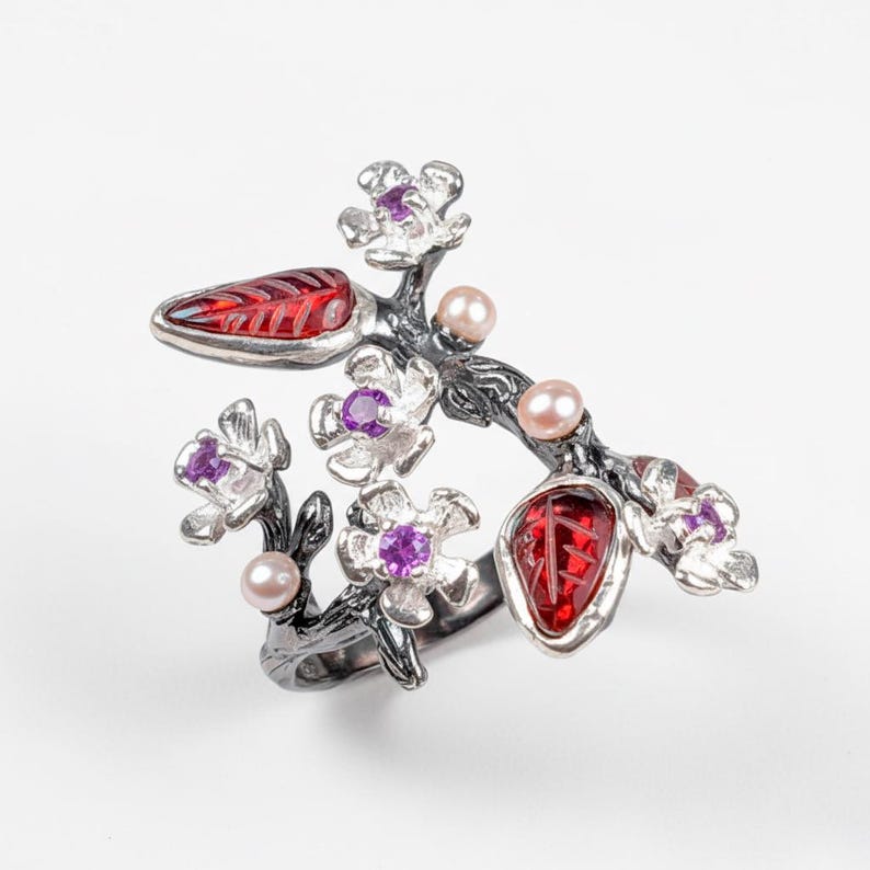 Blossom floral ring crafted in silver, celebrating October birthstone and artisan detail.