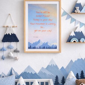 Peut inclure: Une affiche encadrée représentant un paysage de montagne avec le texte : You're off to Great Places! Today is your day! Your mountain is waiting, So... get on your way! Dr Seuss. L'affiche possède un cadre en bois clair et un ciel bleu et orange.