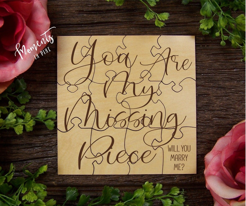 Pu&ograve; includere: Pezzo di puzzle in legno con il testo "You are my missing piece" e "Will you marry me?" in corsivo marrone su uno sfondo marrone chiaro.