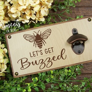 May include: Wooden wall mounted bottle opener with a bee design and the text "Let's Get Buzzed".
