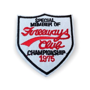 May include: Embroidered patch in a shield shape with a white background and black border. The patch features the text "SPECIAL MEMBER OF Freeways Club CHAMPIONSHIP 1975" in red and black thread.