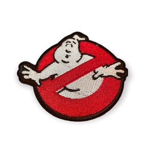 May include: Embroidered patch featuring the Ghostbusters logo. The design includes a white ghost figure inside a red circle with a diagonal red line through it. The patch has a black border and is likely for clothing or accessories.