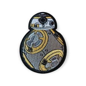 May include: Embroidered patch featuring the BB-8 droid from Star Wars. The patch has a detailed design with gray, yellow, and black colors. The patch is oval-shaped with a black border.