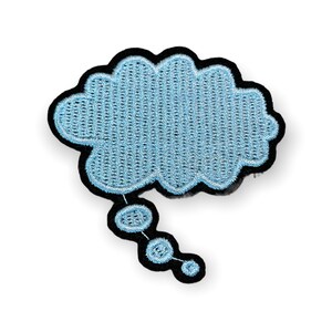 May include: A light blue embroidered thought bubble patch with a black border. The patch has a textured appearance and a series of connected circles extending from the bottom. This patch is suitable for clothing or accessories.