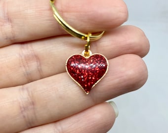 May include: A gold key chain with a red glitter heart charm.