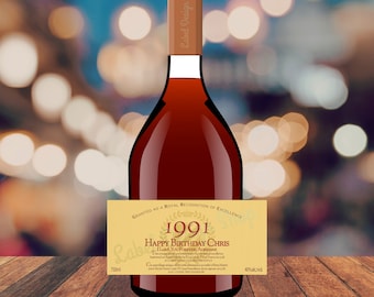 May include: A glass bottle filled with dark amber liquid, featuring a tan rectangular label with the text 1991, Happy Birthday Chris, I Love You Forever, Adrienne, and other small print. The bottle has a brown cap and a 750ml volume label.