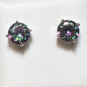 Pu&ograve; includere: Un paio di orecchini a perno d'argento con pietre preziose rotonde e iridescenti. Le pietre preziose presentano un arcobaleno di colori, tra cui verde, blu, viola e rosa.