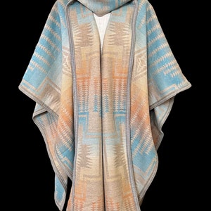 May include: A hooded poncho with a geometric pattern in shades of blue, beige, and orange. The poncho is made of a soft, woven fabric and has a fringed edge.