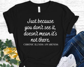 May include: Black t-shirt with white text that reads "Just because you don't see it, doesn't mean it's not there."  The text is centered on the shirt and is followed by the words "CHRONIC ILLNESS AWARENESS".