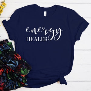 Pode incluir: Camiseta azul marinho com texto branco que diz "energy HEALER" em letra cursiva.