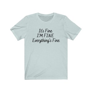 May include: A light blue t-shirt with the text "It's Fine I'M FINE Everything's Fine" printed in black.