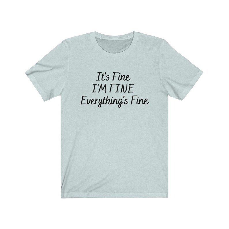 May include: A light blue t-shirt with the text "It's Fine I'M FINE Everything's Fine" printed in black.