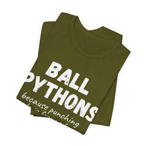 May include: Olive green t-shirt with the text "BALL PYTHONS" in large white letters, with the phrase "because punching is frowned upon" below. The shirt is folded.