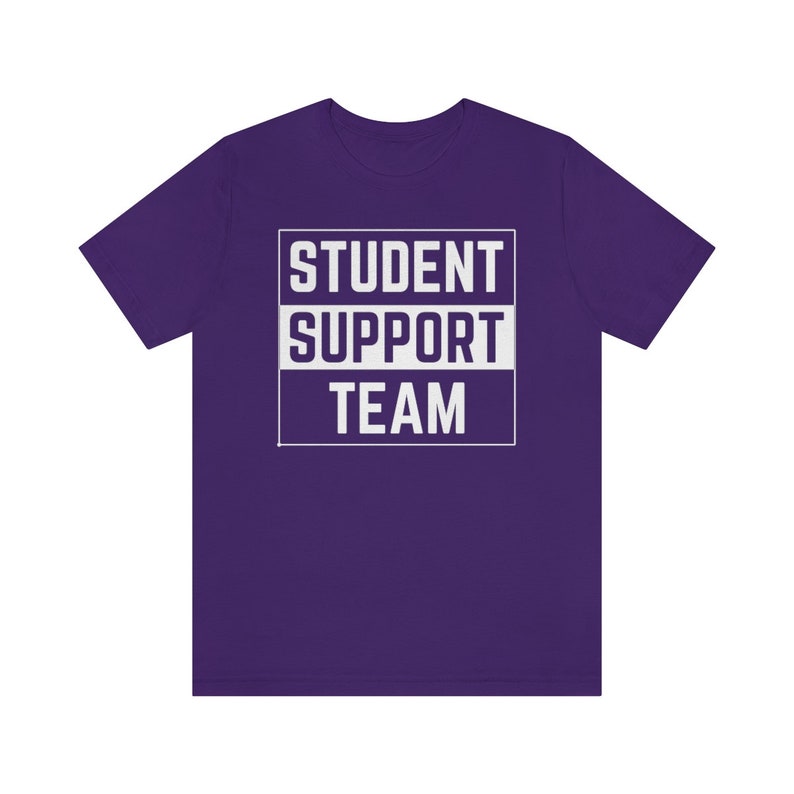 Może przedstawiać: Fioletowy T-shirt z białym tekstem, kt&oacute;ry brzmi "STUDENT SUPPORT TEAM" w ramce.