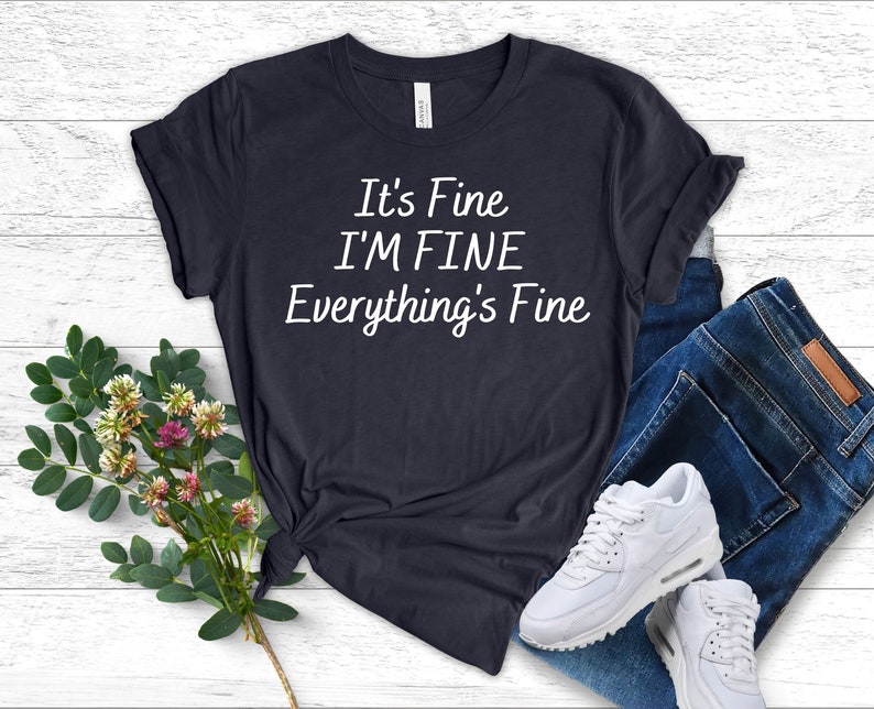 May include: A dark blue t-shirt with the text "It's Fine I'M FINE Everything's Fine" printed in white.