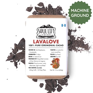 May include: A package of Soul Lift Cacao Lavarove 100% Pure Ceremonial Cacao. The package is white with red and black text and a Guatemalan flag. The package is surrounded by pieces of dark chocolate and a green "Machine Ground" label.