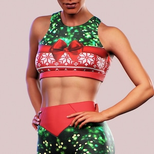 Puede incluir: Un conjunto deportivo con temática navideña que incluye un sujetador deportivo y leggings. El sujetador tiene un diseño de lazo rojo y copo de nieve sobre un fondo verde. Los leggings tienen un patrón verde brillante con lazos rojos y detalles de copo de nieve.