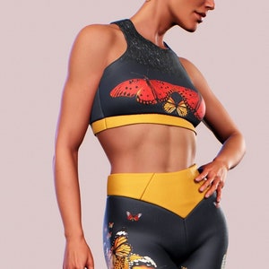 May include: A black and yellow sports bra and leggings set with a butterfly print. The leggings have a yellow waistband and a butterfly print all over.